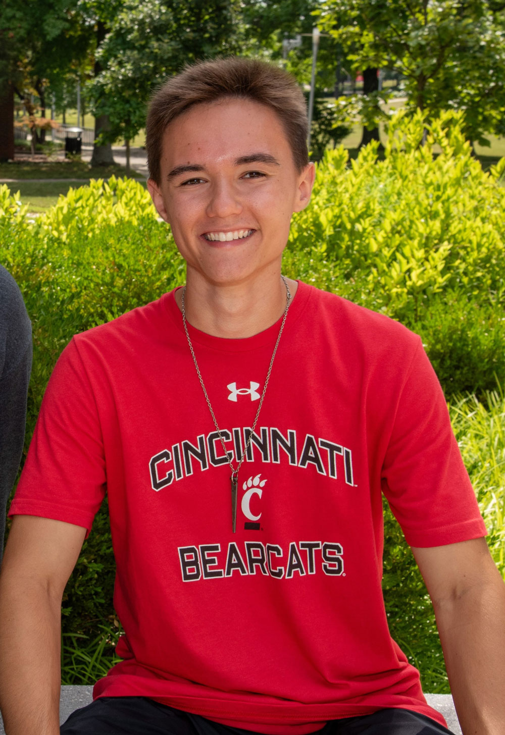smiling male student sitting outside