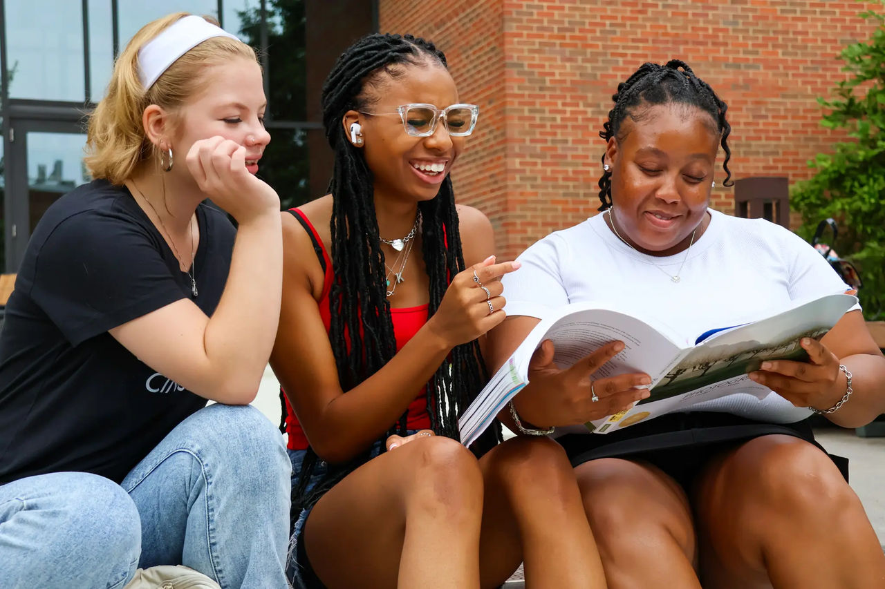 three female students laughing outside on the UC Blue Ash campus