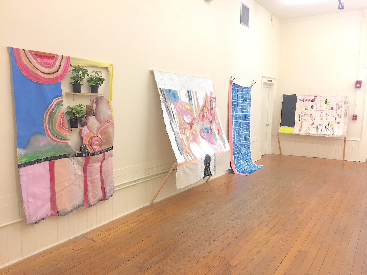 Abstract artwork displayed along the walls of the UC Blue Ash College gallery