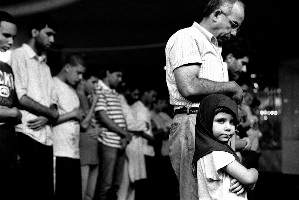 1. Young Girl at Prayers with Her Father, Muslim American Society, Brooklyn NY,  gelatin silver photograph, 16”x20” (2010)