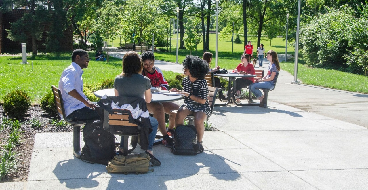 Students sitting at tables outside of Progress Hall