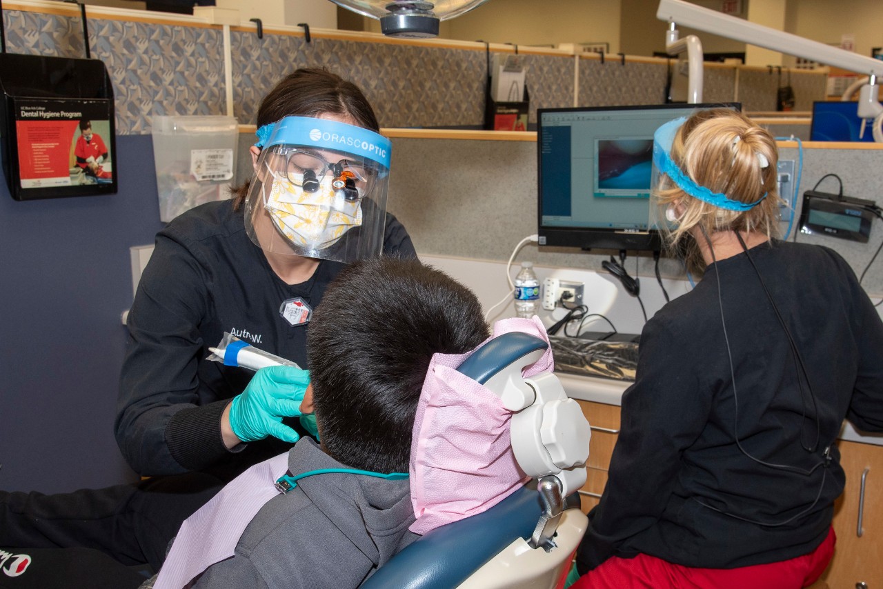 student in the dental hygiene lab with patient