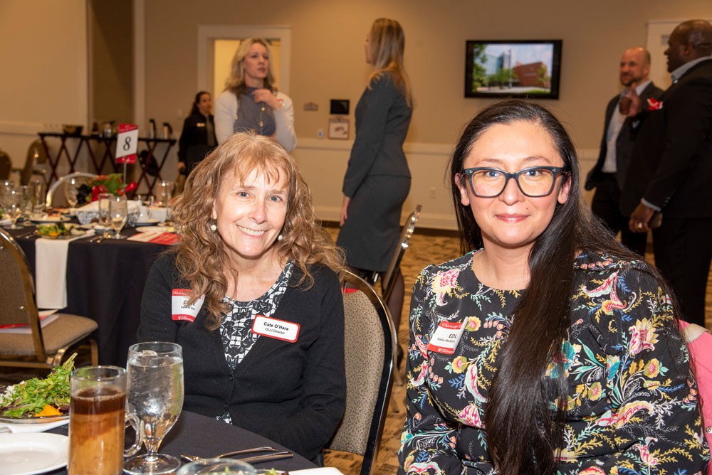 Edlin Maldonado-Fuller sitting at a table with female professor during event