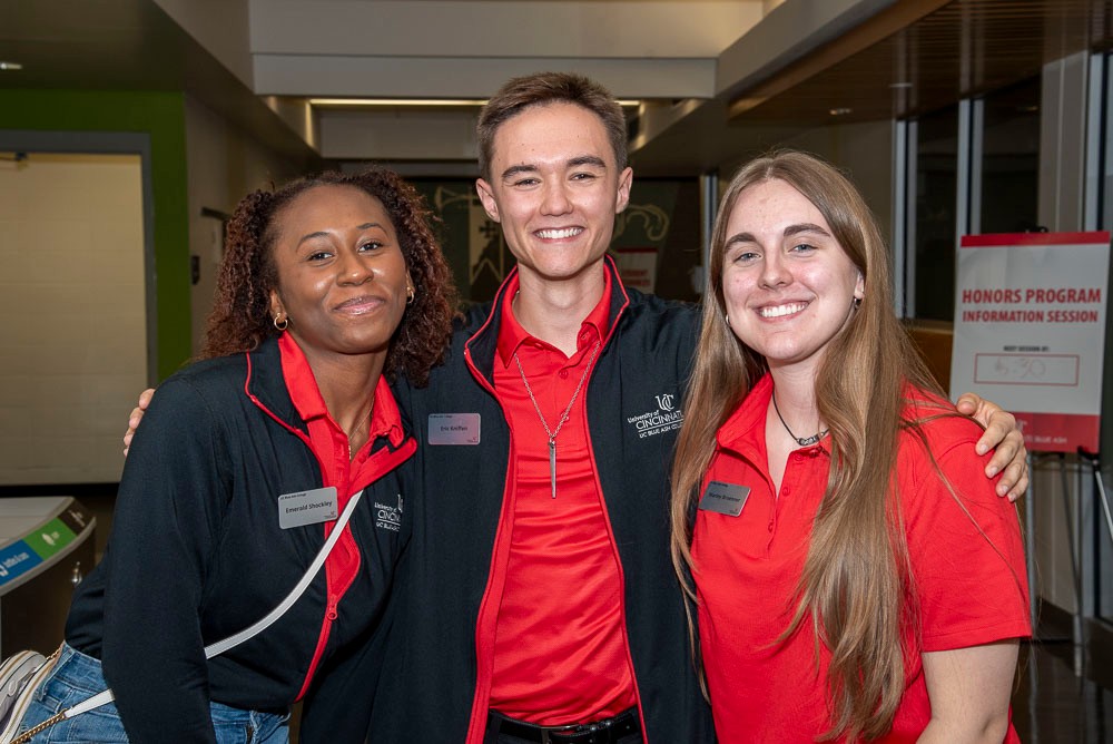 Three students smiling for camera at an event