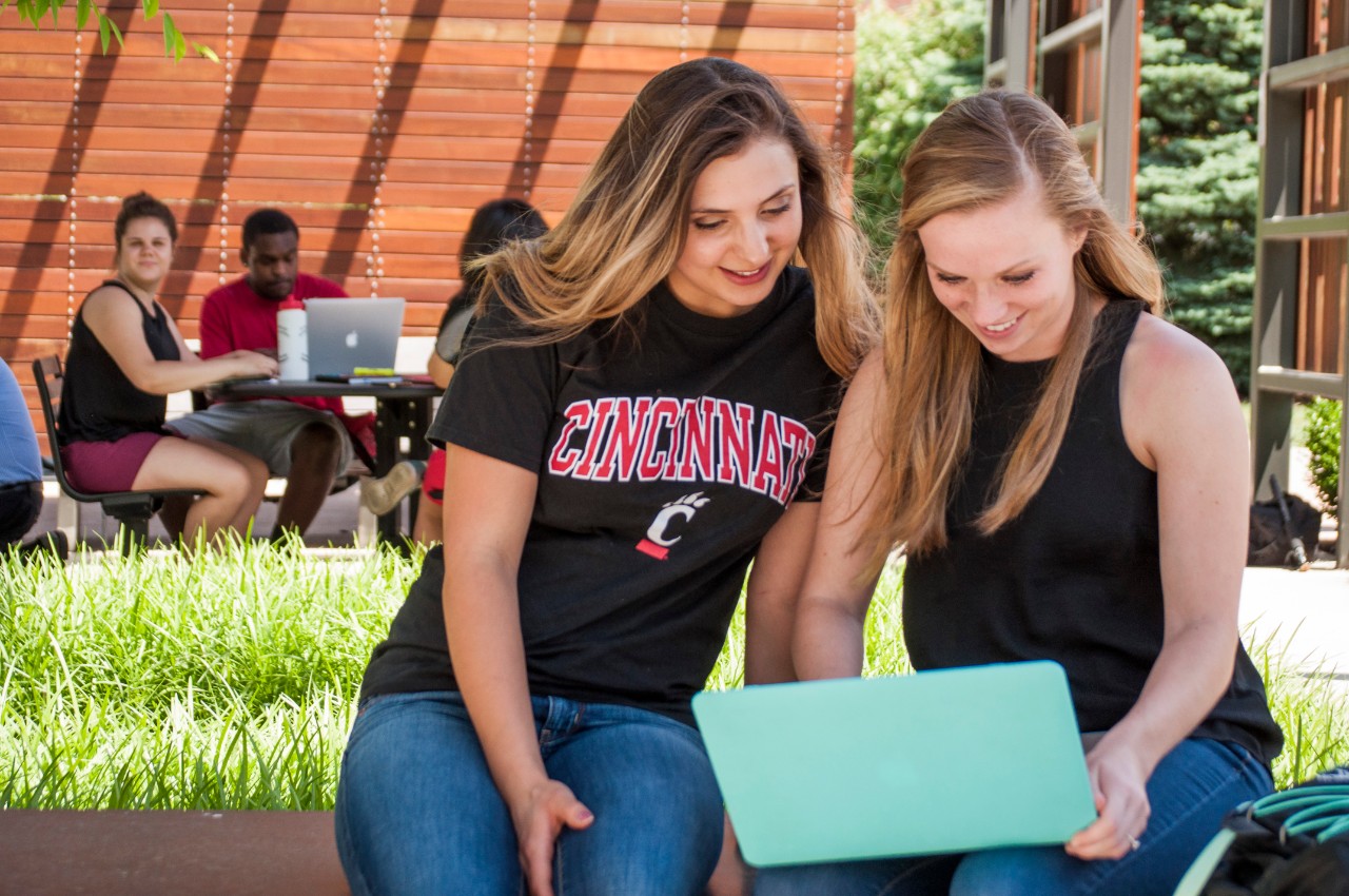 Two students working on laptop at UC Blue Ash College
