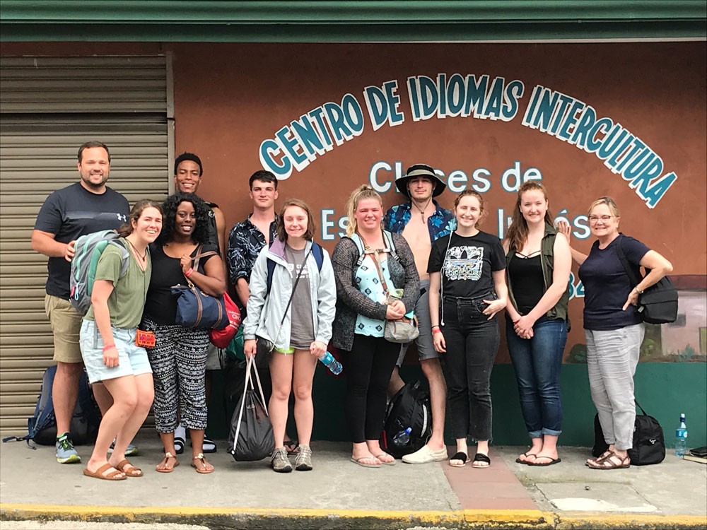 group of study abroad students posing in front of Costa Rican sign