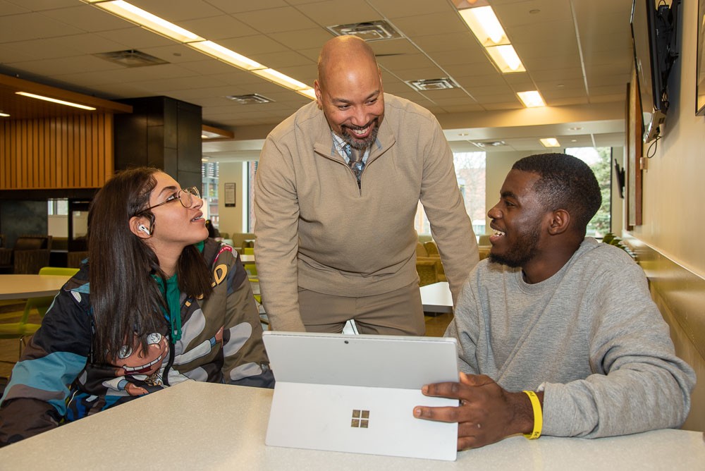 Brad Mallory talking with two students in common area