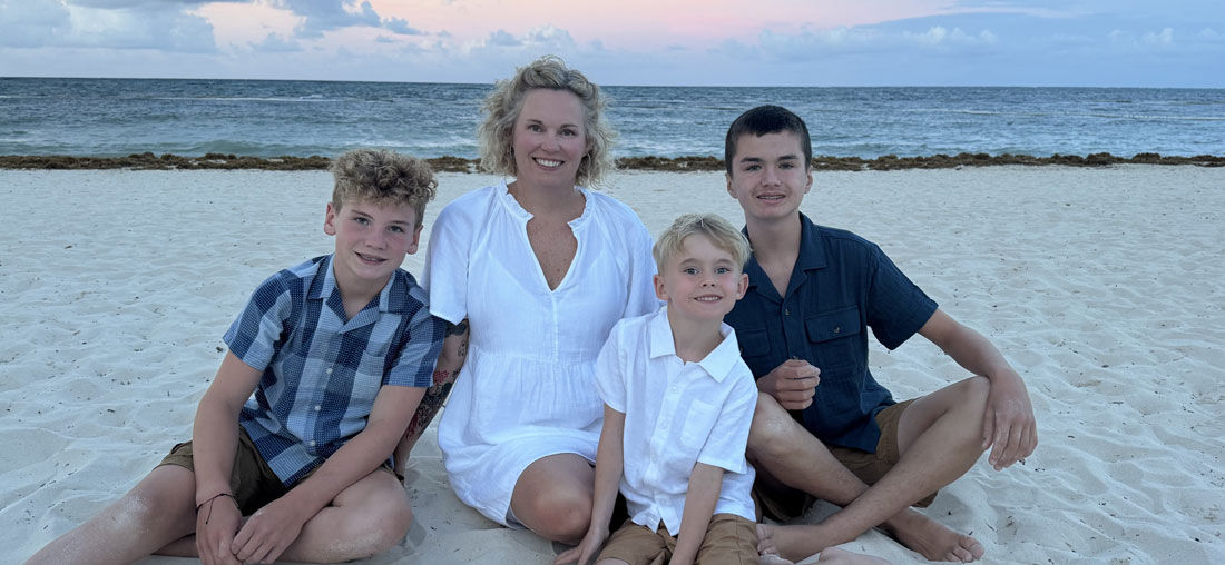 mom and three sons on beach