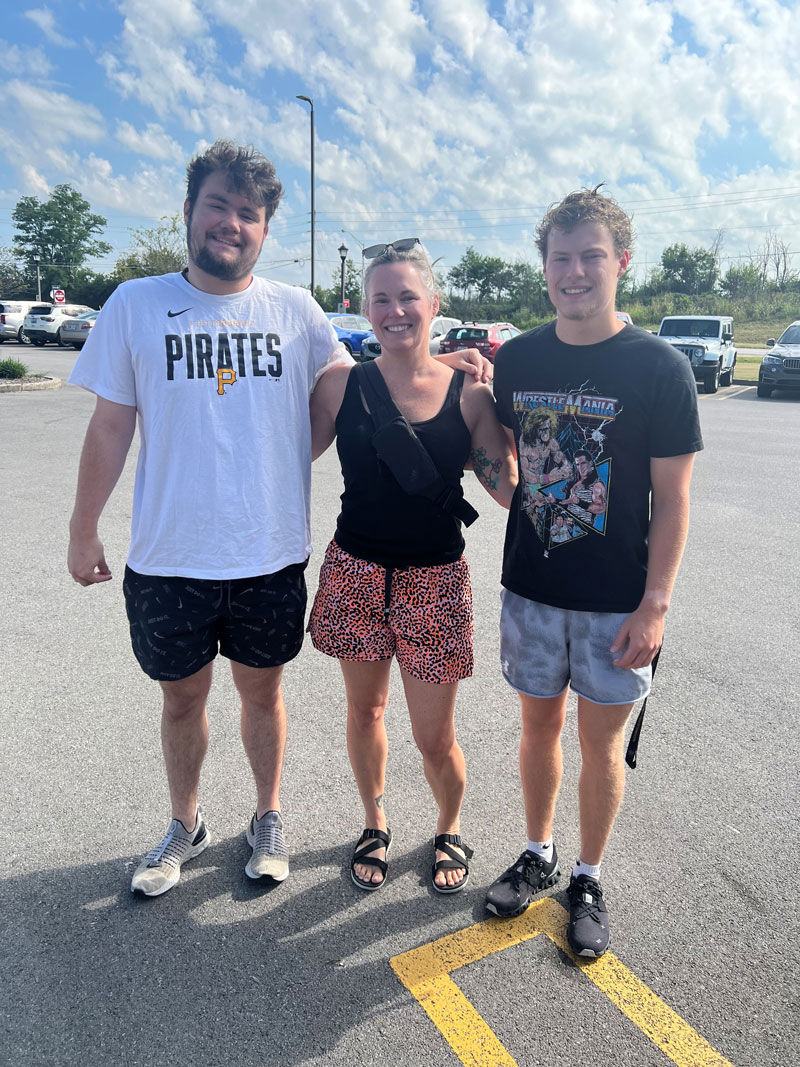 Brandi Thomas with two adult sons outside