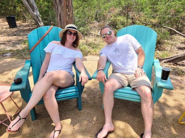 two people reclining on a beach in blue chairs