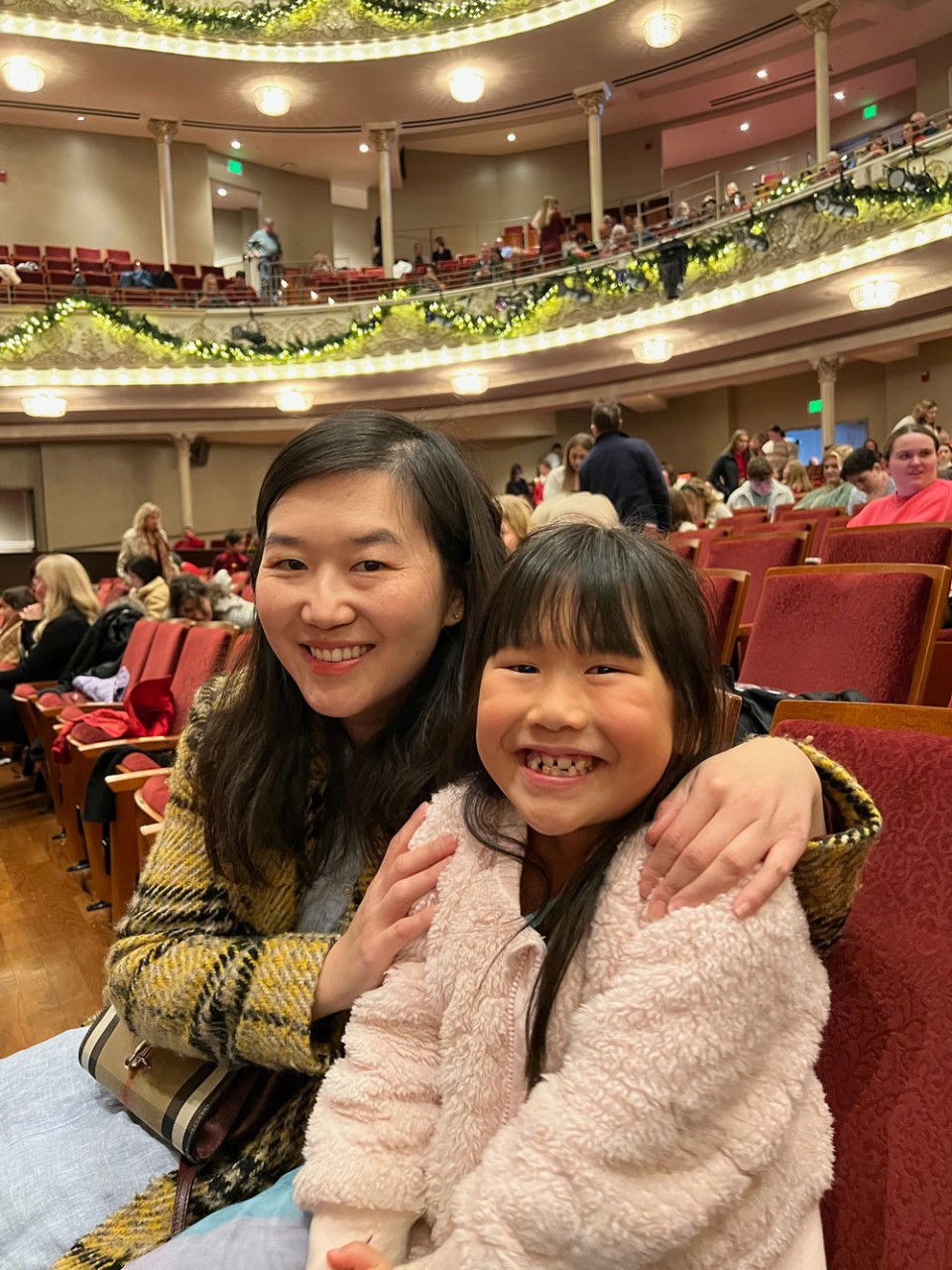 mother and daughter smiling at ballet performance