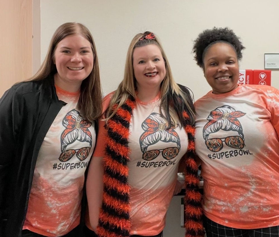 three women smiling and dressed in Bengals gear