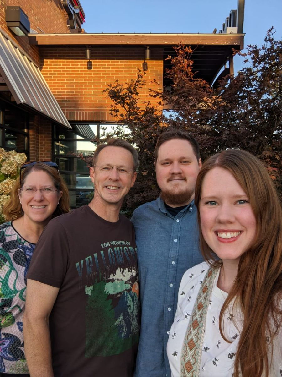 family selfie of four people outdoors