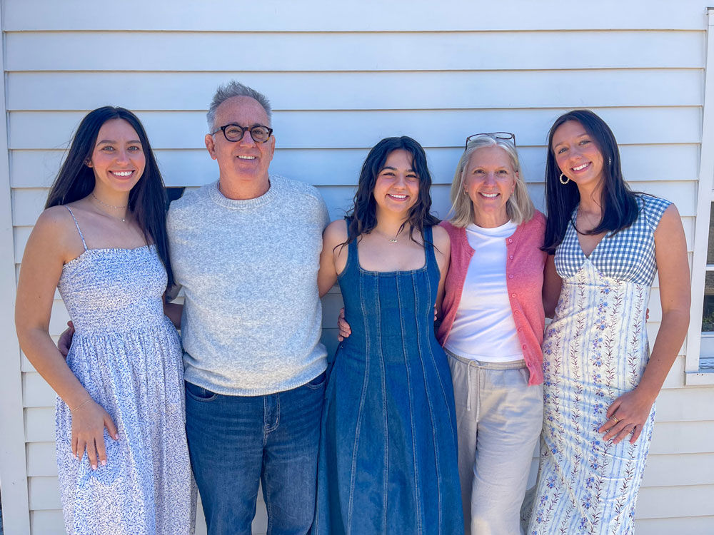 family of five people smiling and posing together