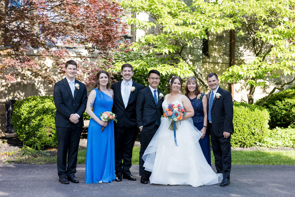 large family group posing with bride and groom at outdoor wedding