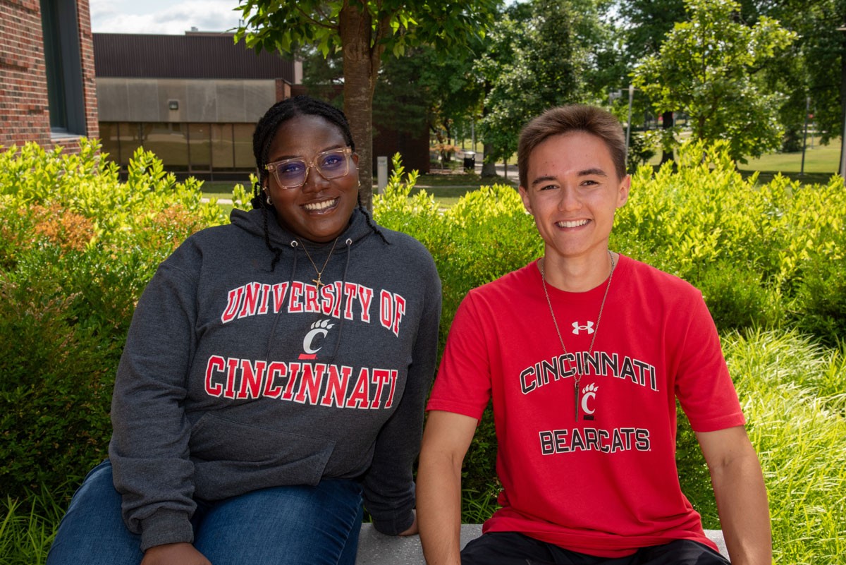 Two students smiling outside on the UC Blue Ash patio