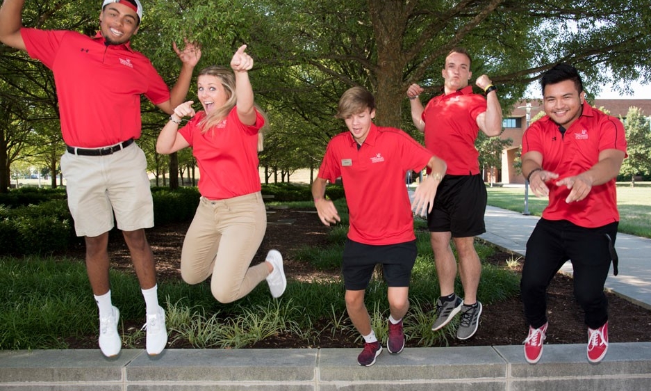 Student orientation leaders jumping and laughing together