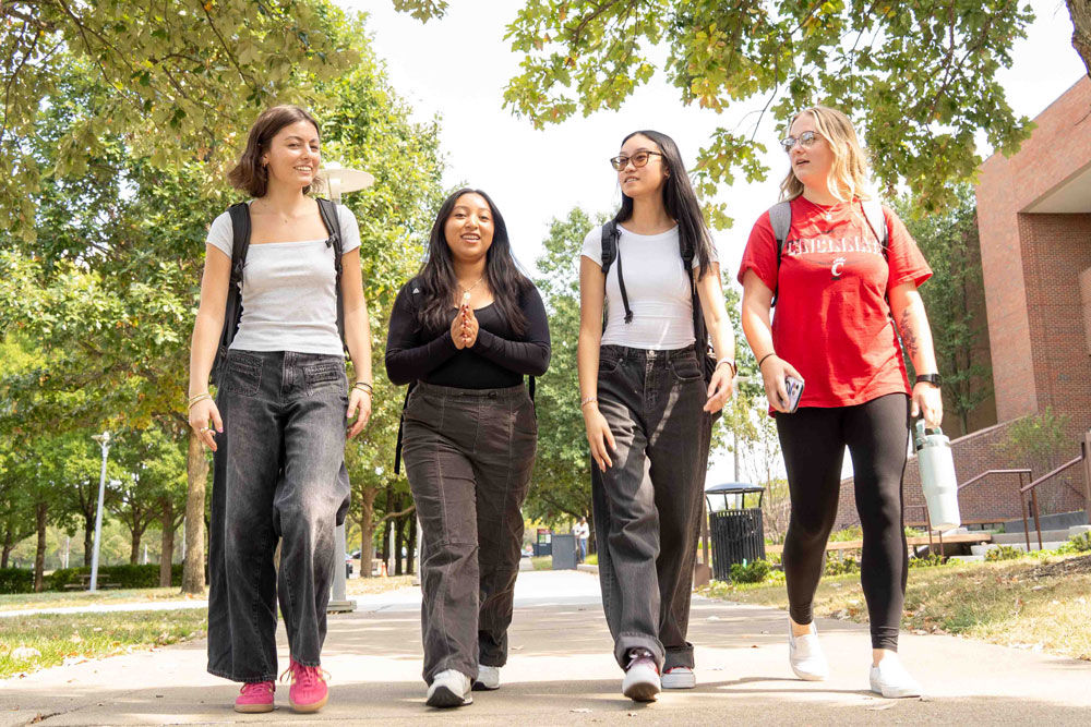 four female students walking outside on campus