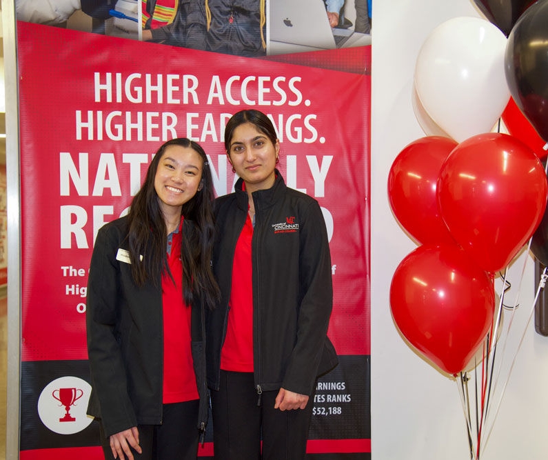 two students smiling at an Open House event with balloons