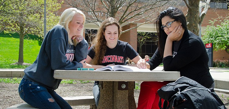 Three female students working outside at UC Blue Ash