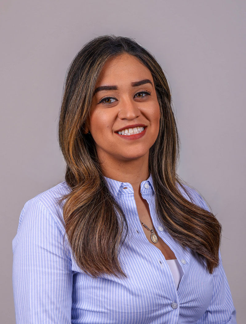 Desiree Gonzales leaning on tree